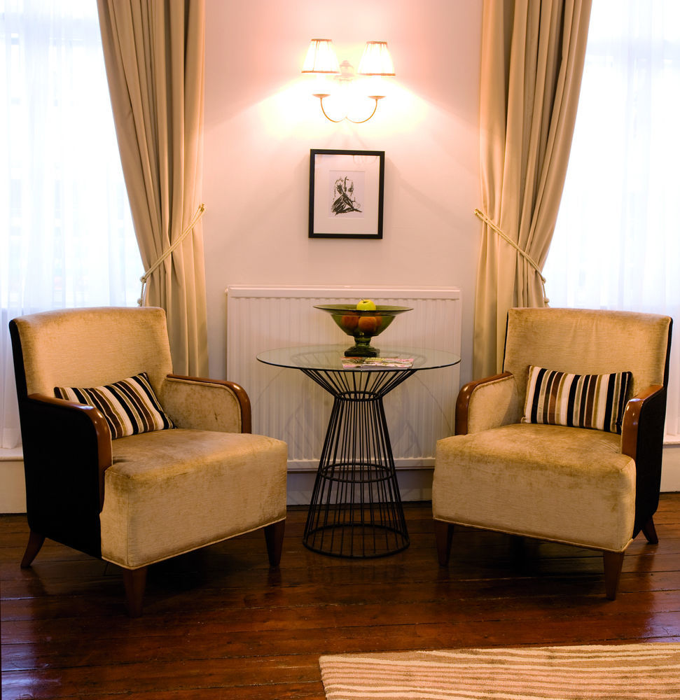 The Fleece At Сайренстер Экстерьер фото A pair of club chairs